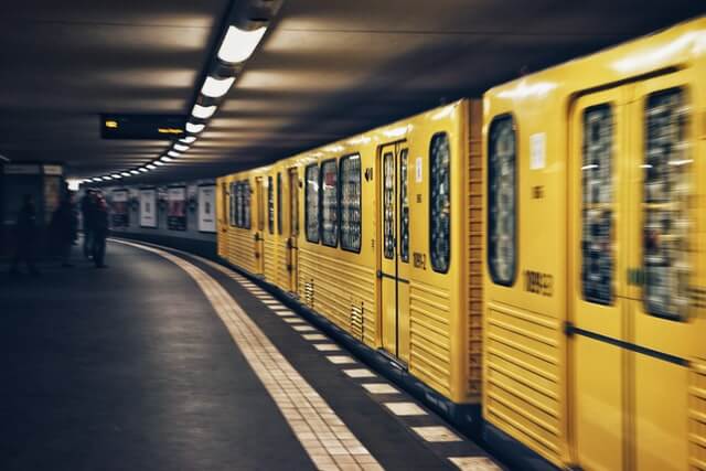 yellow metro in station|close up of train tracks